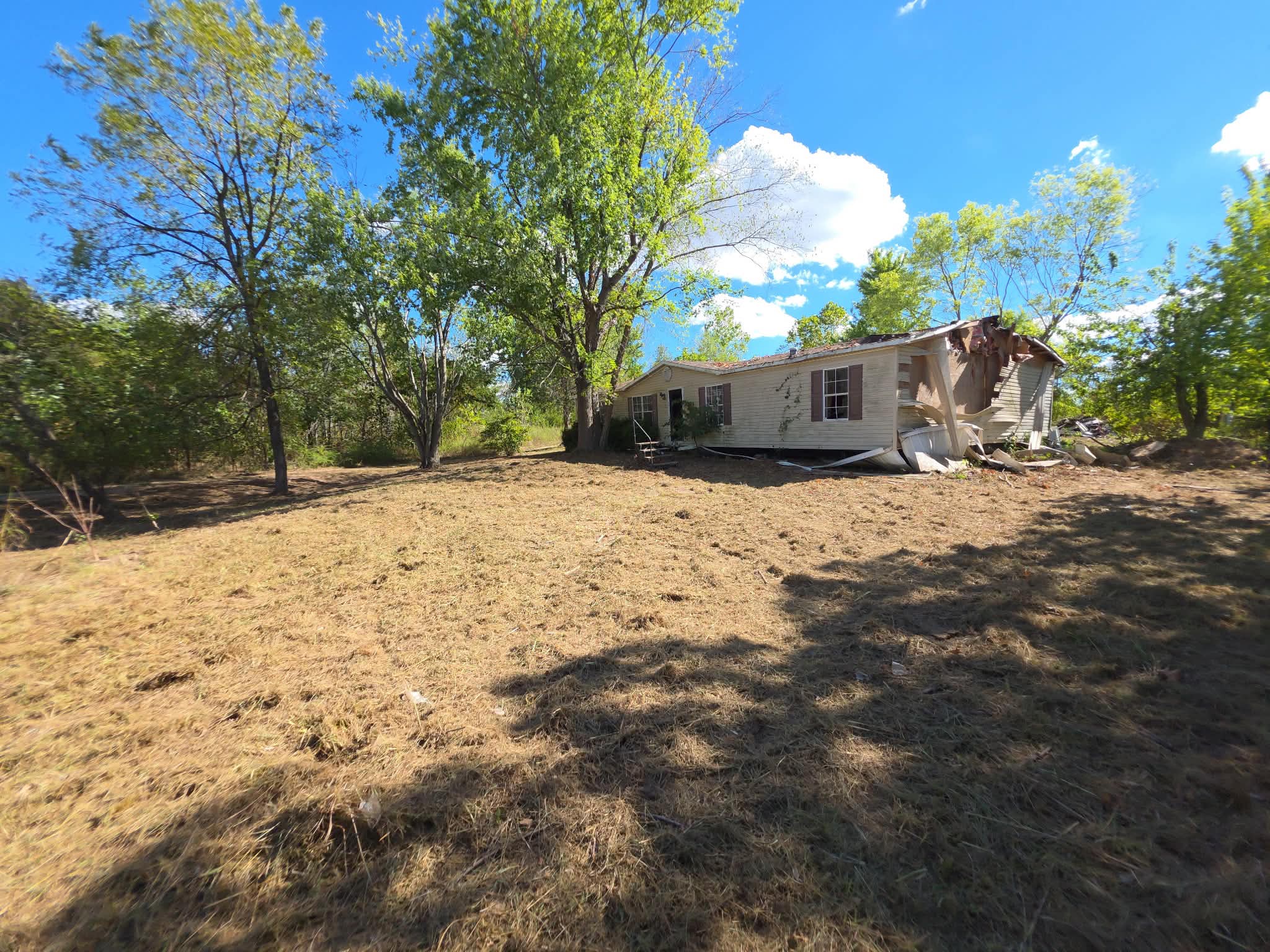 After: the fallen tree has been removed and the yard cleared
